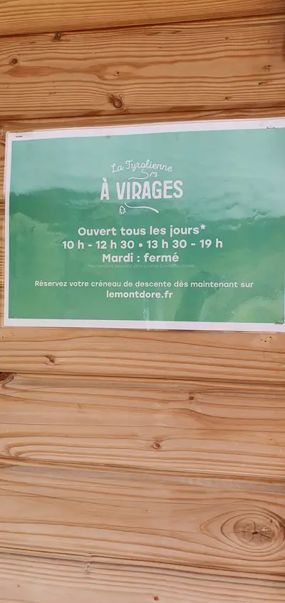 panneau avec les horaires d'ouverture de la tyrolienne à virages