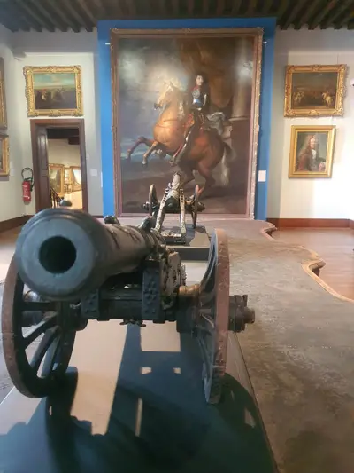canon devant un tableau de Louis XIV