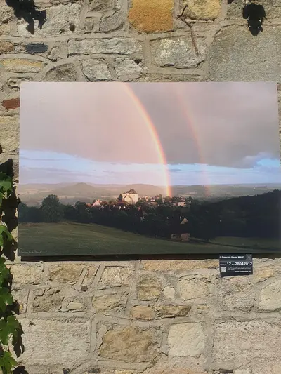 exposition photo curemonte avec un arc-en-ciel
