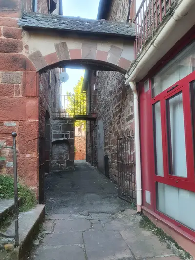 porche en grès rouge menant vers une ruelle