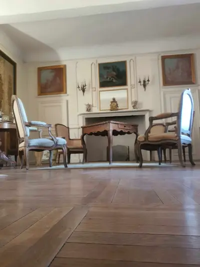 salon avec table, fauteuils et parquet ciré