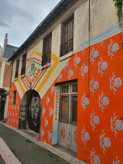 Façade peinte avec des fleurs sur fond orange