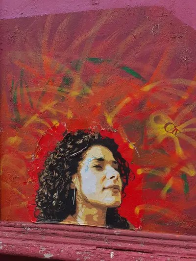 Fresque d'une femme brune avec les cheveux bouclés sur fond rouge