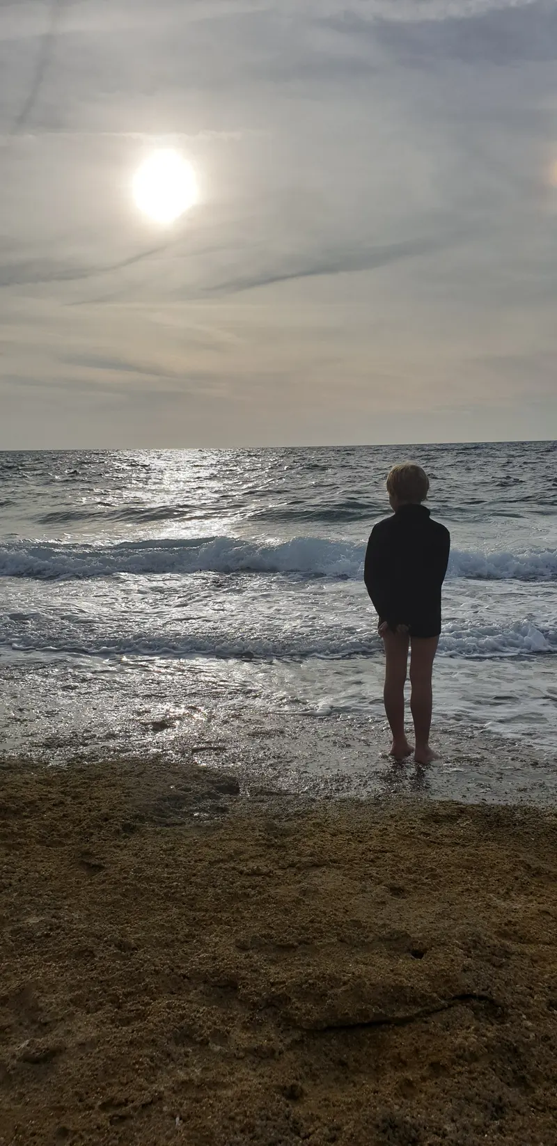 Enfant devant le soleil qui se couche