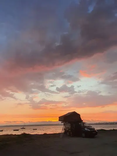 Installation tente de toit véhicule au coucher de soleil