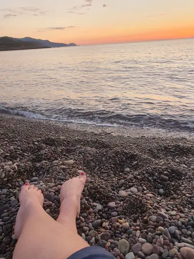 Pieds dans les graviers devant le coucher de soleil