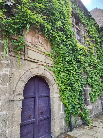 Façade du château avec la porte d'entrée et le blason